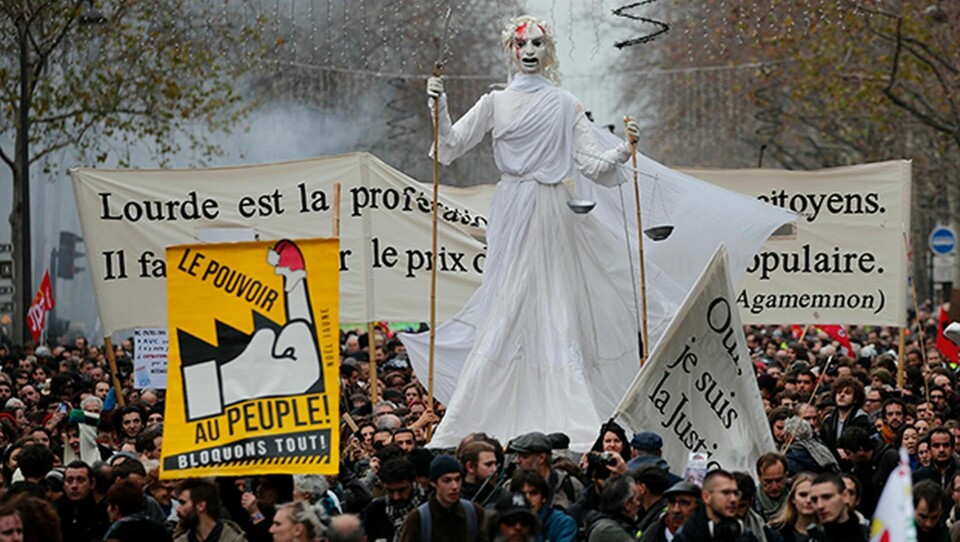 Makten åt folket - vi blockerar allt! står det på ett av plakaten. Demonstrationer mot den franska regeringens pensionsreform genomfördes runt om i Frankrike i december 2019. Foto: Francois Mori/AP/TT