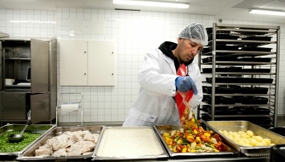 En anställd på Sodexos storkök i Märsta förbereder maten som plockas ihop i matlådor till sjukhus och äldreboenden.